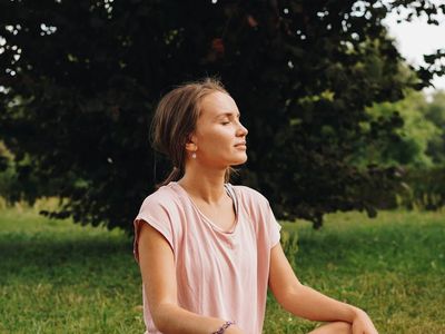 A person sitting peacefully with eyes closed, focusing on breath.