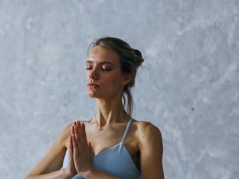 Person holding a difficult balancing yoga pose with focus.